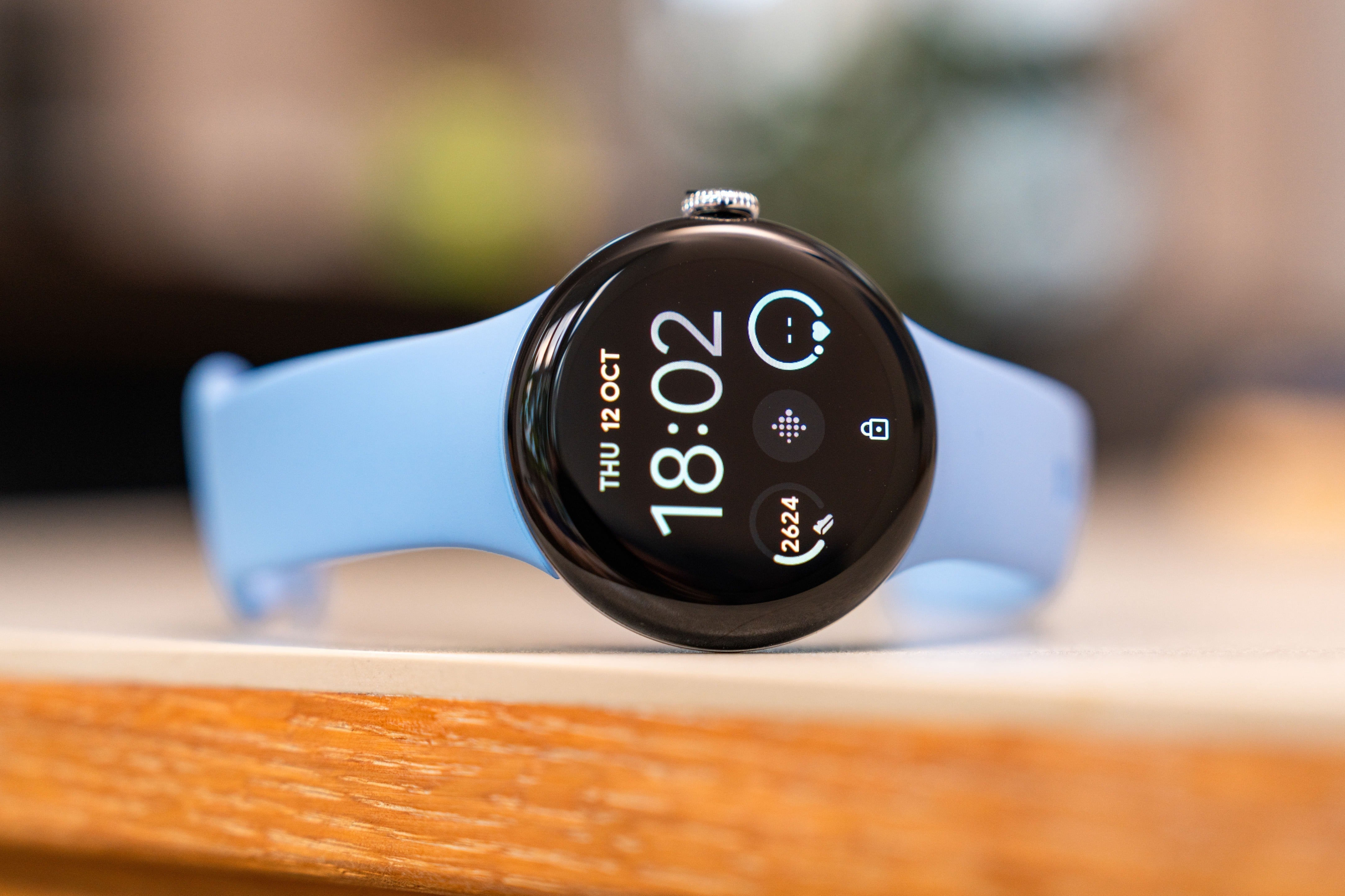 A Blue Pixel Watch 2 on a wood table