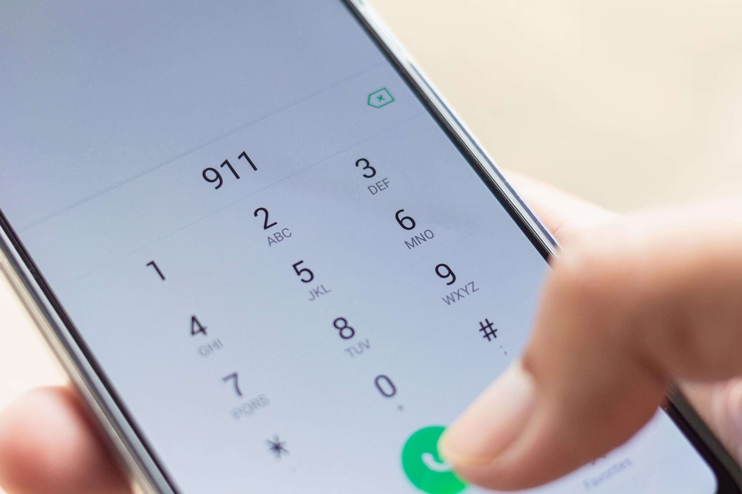 man dialing 911 on a phone